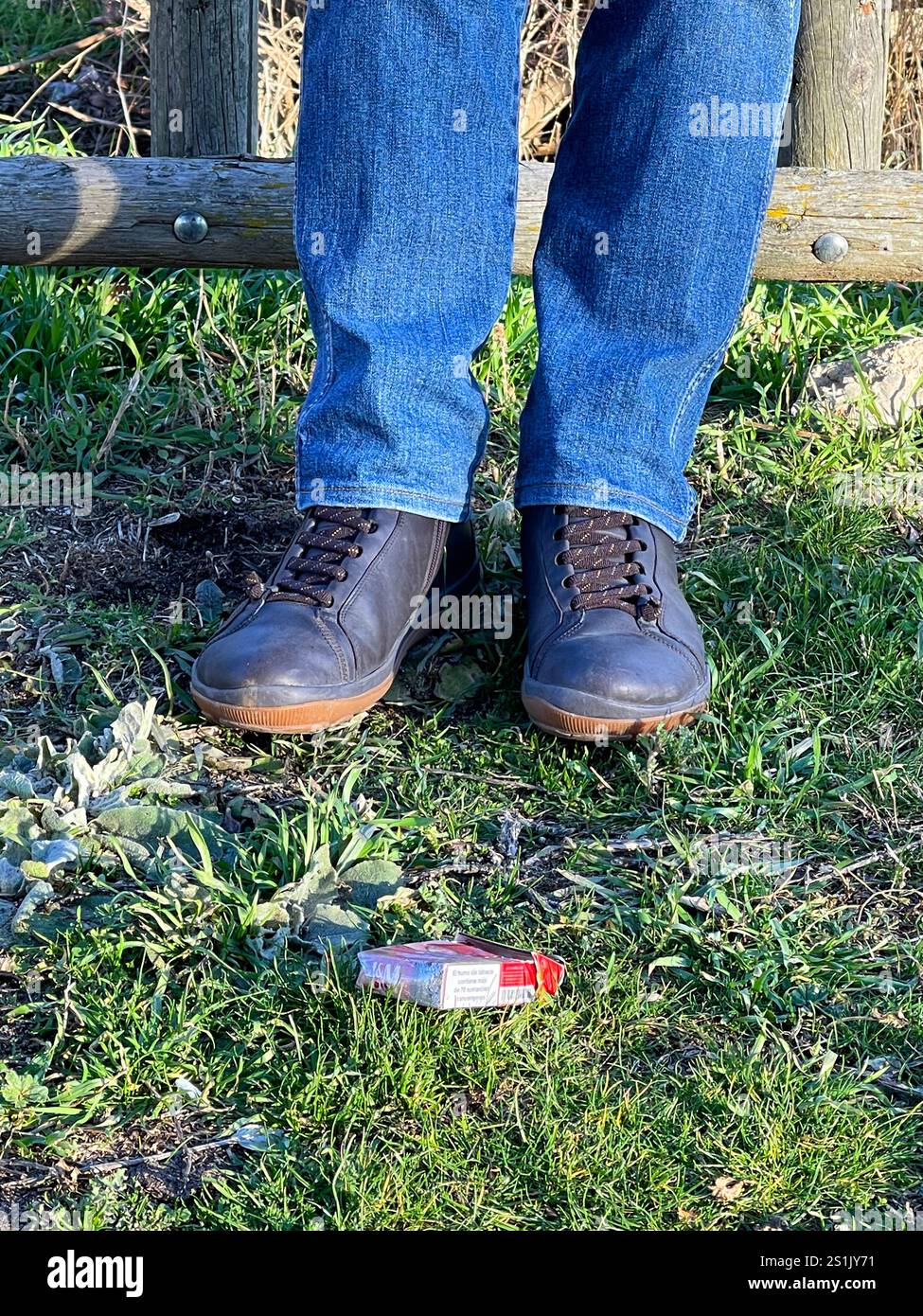 Man’s legs and packet on the grass. - Smartphone Captured Stock Image