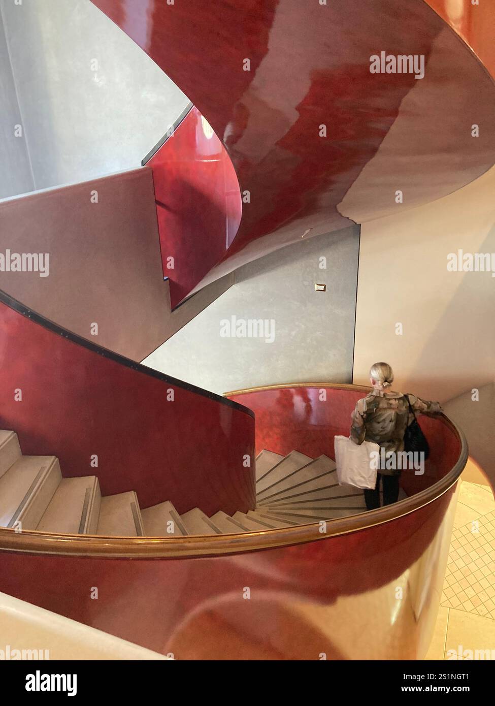 Descending a modern, red spiral staircase - Smartphone Captured Stock Image