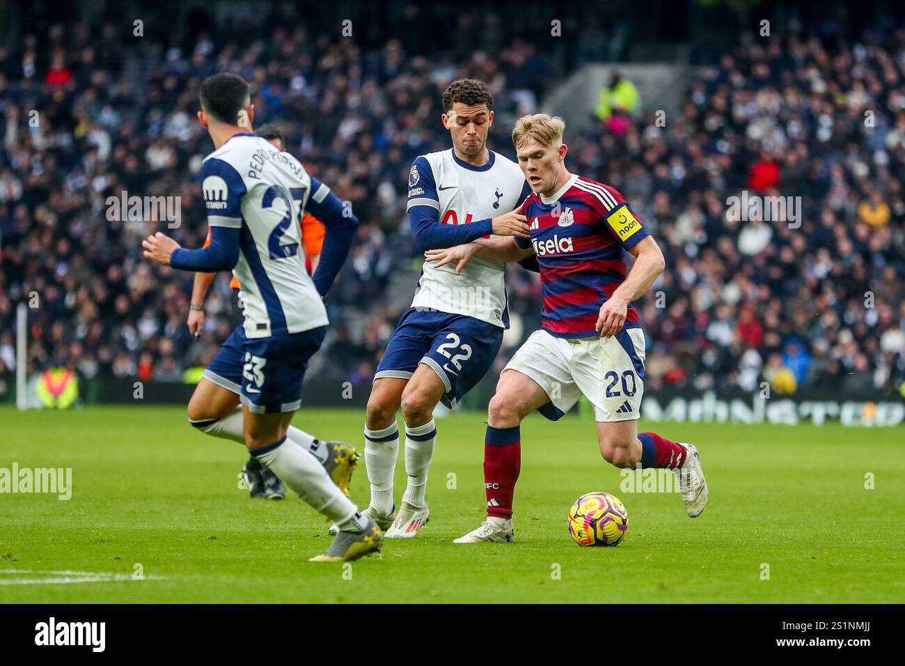 Lewis Hall of Newcastle United is put under pressure by Brennan Johnson