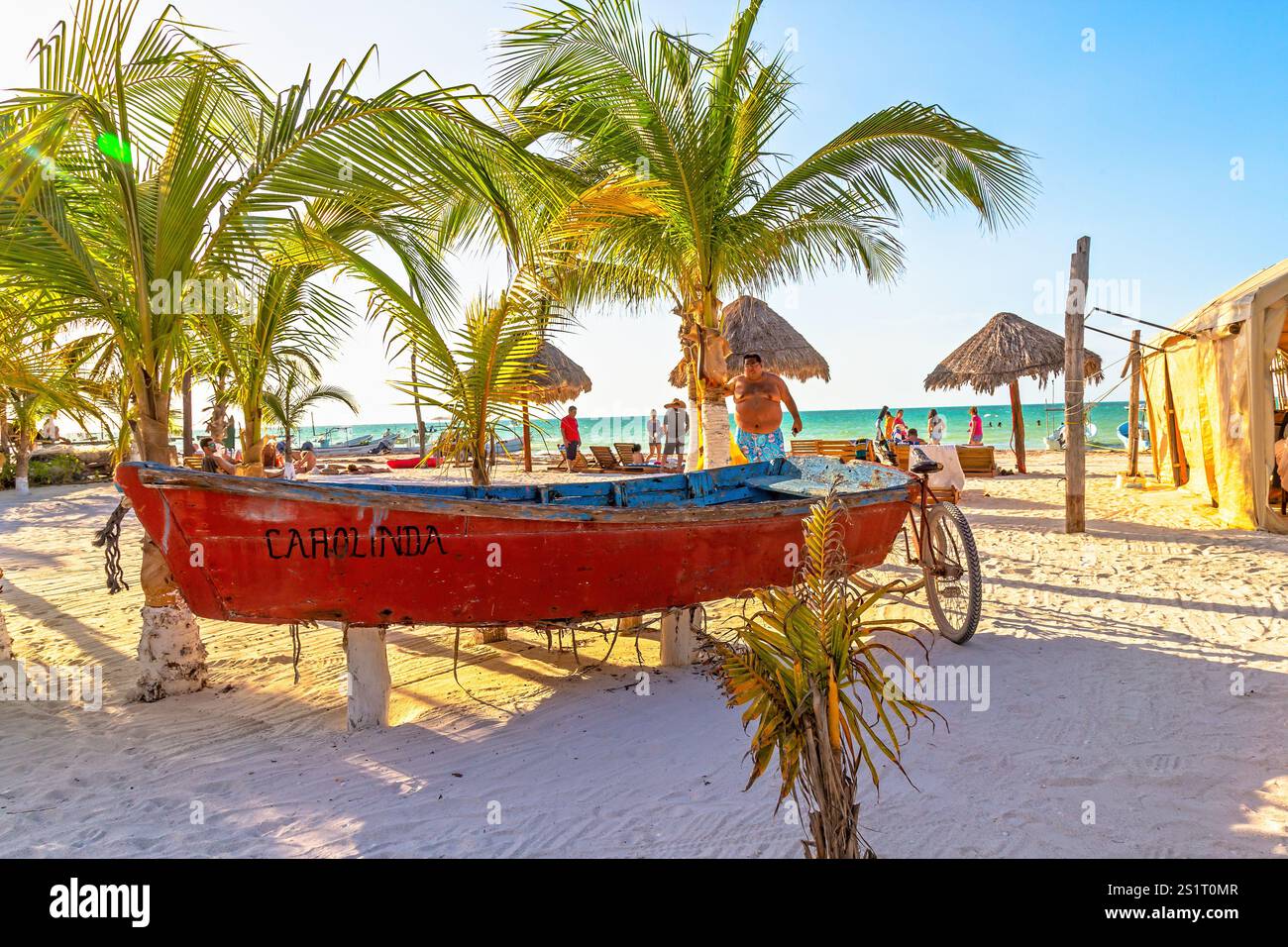Bright Tropical Beach Scene with Red Boat and Palm Trees, Isla Holbox, Mexico Stock Photo