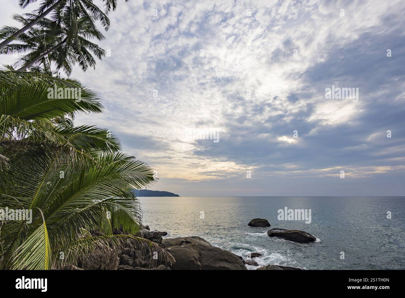 Wild beach with surf on the coast facing the Indian Ocean. Palm trees and high waves at sunset. Patong, Kathu, Phuket Island, Thailand, Asia Stock Photo