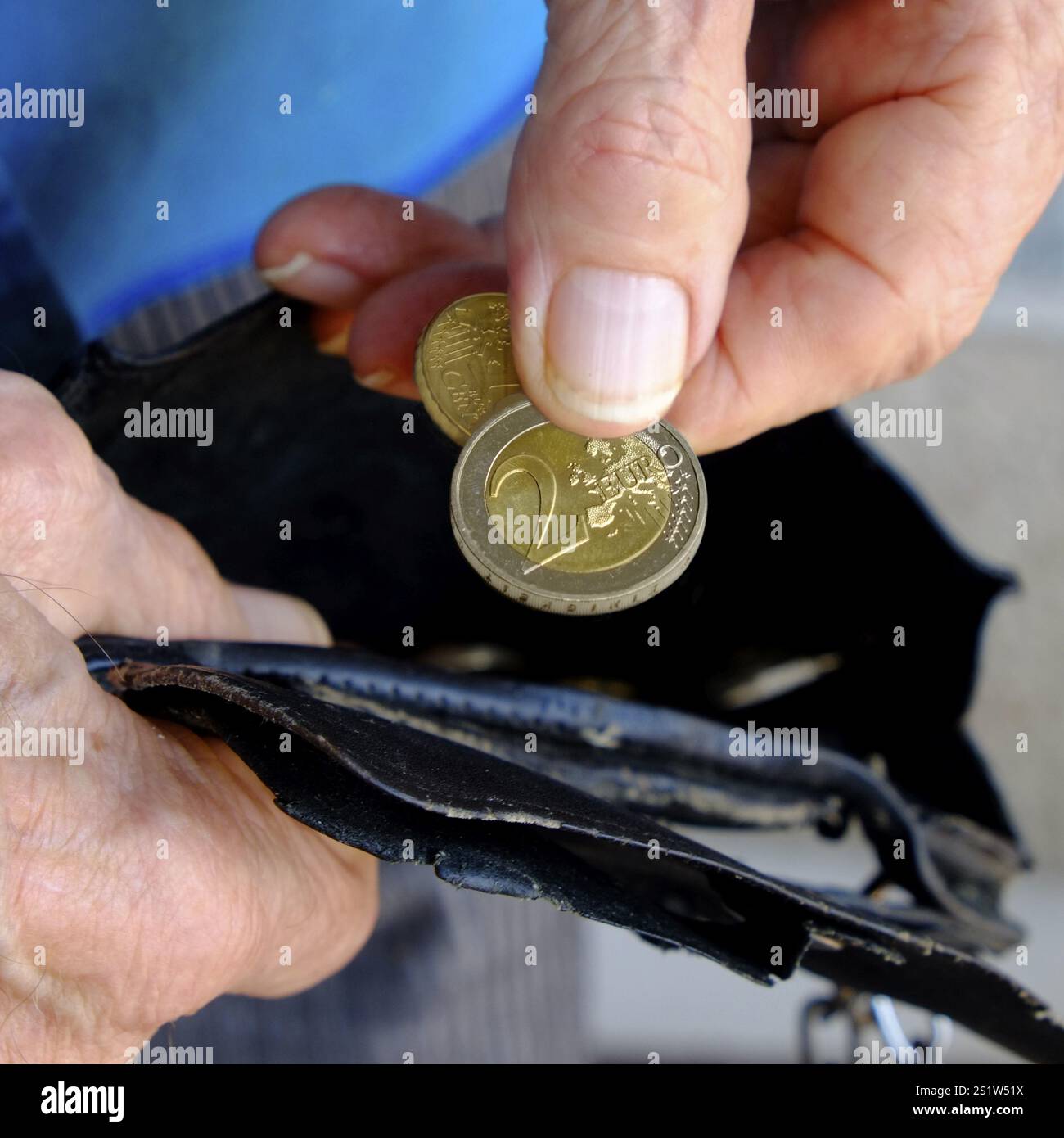 Poverty: The fingers of an old man remove two euro coins from a worn ...