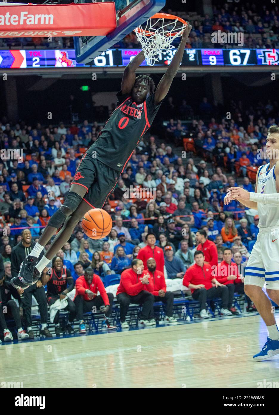 San Diego State's Magoon Gwath (0) hangs from the rim after dunking