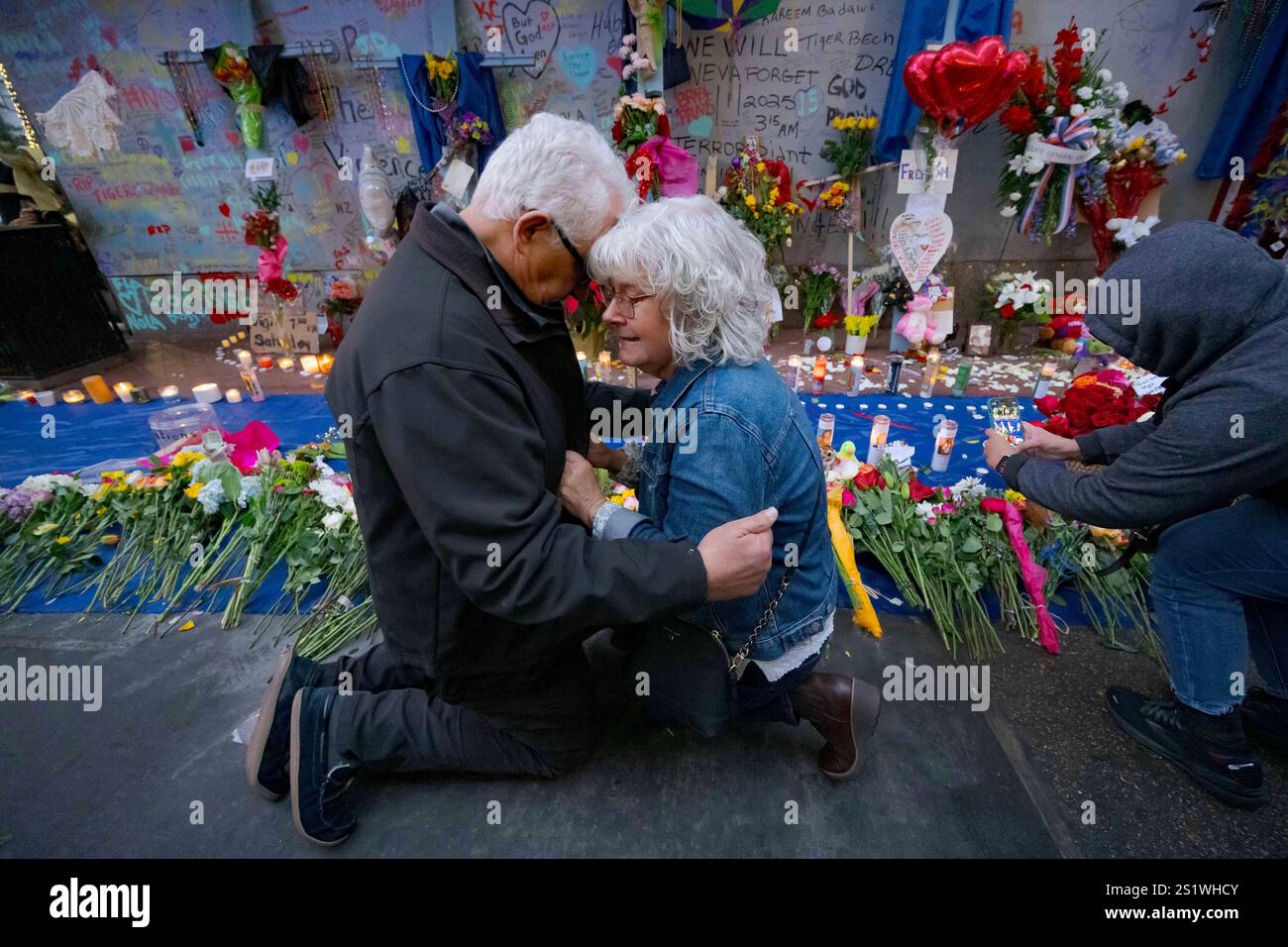 Long Island, New York residents Louis Tenedorio, left, and his wife, Cathy Tenedorio, embrace on by a memorial Bourbon Street and Canal Street in New Orleans, Saturday, Jan. 4, 2025, where their son, Matthew Tenedorio, was killed as one of the victims of the New Year's Day deadly truck attack and shooting. (AP Photo/Matthew Hinton) Stock Photo