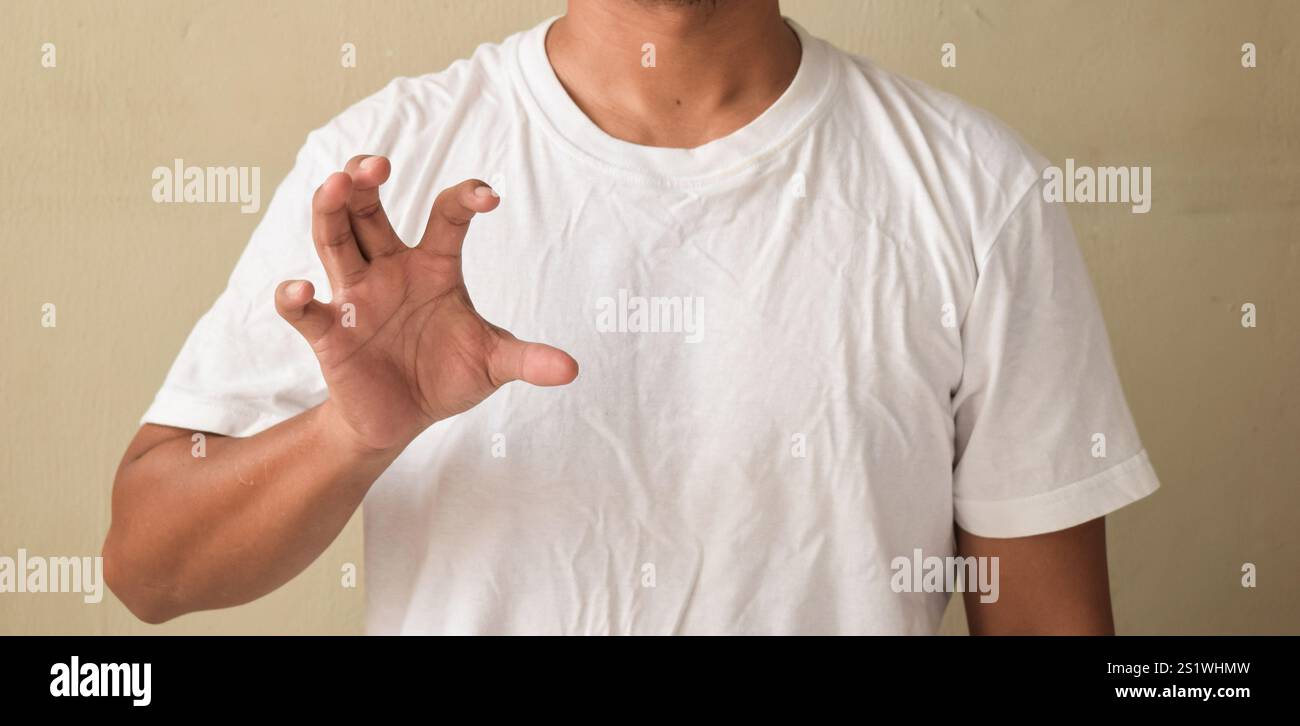 Young man keeping his hand raised while using sign language Stock Photo