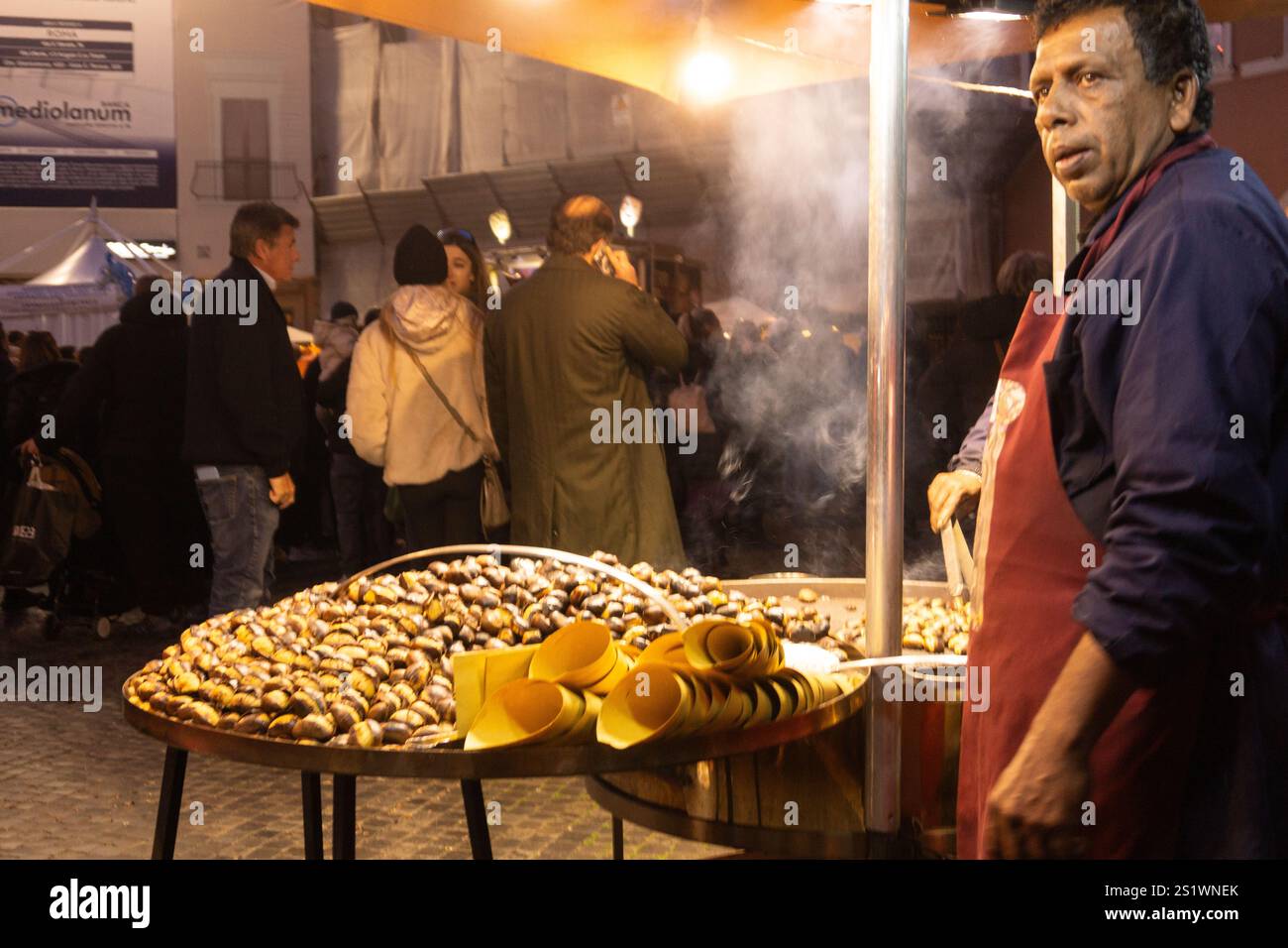 Rome, Italy. Piazza Navona. Man selling 'caldarroste' (roasted chestnuts), a typical winter street food loved by the romans. Stock Photo