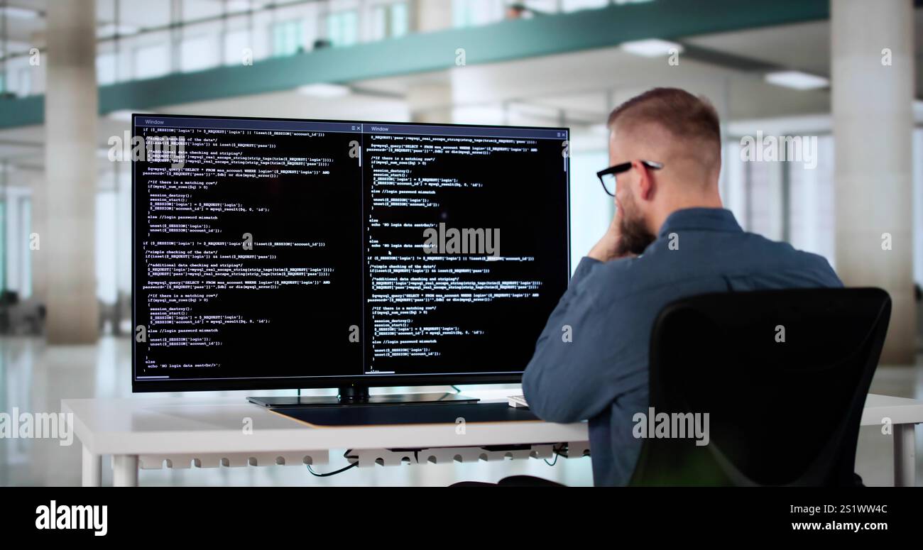 Computer Programmer Writing Program Code On Computer In Office Stock Photo