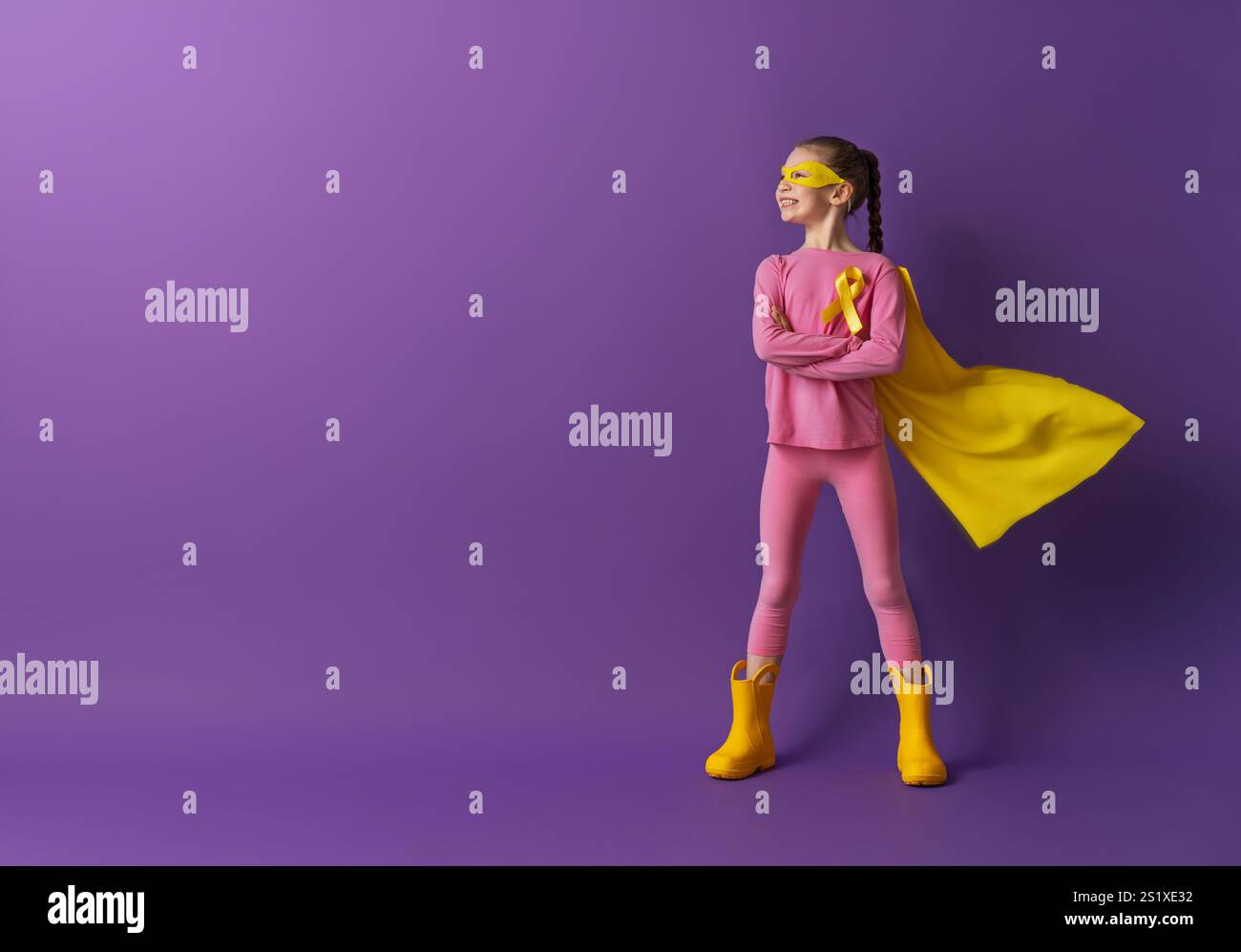 World Childhood cancer Day. Girl in superhero costume with golden ...