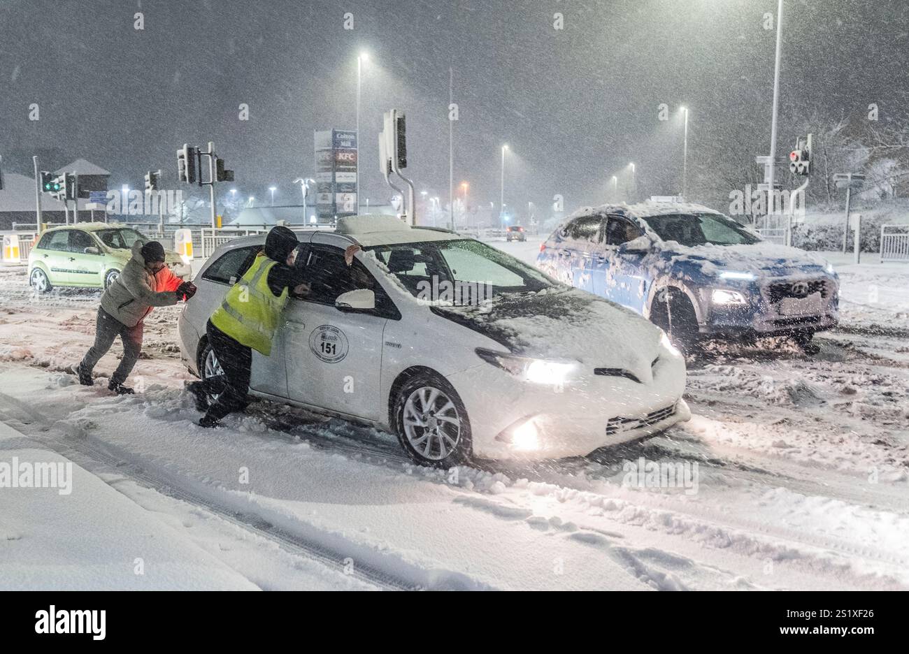 Disruption Cars People help to push cars stuck in snow in Leeds, Yorkshire. Heavy ...