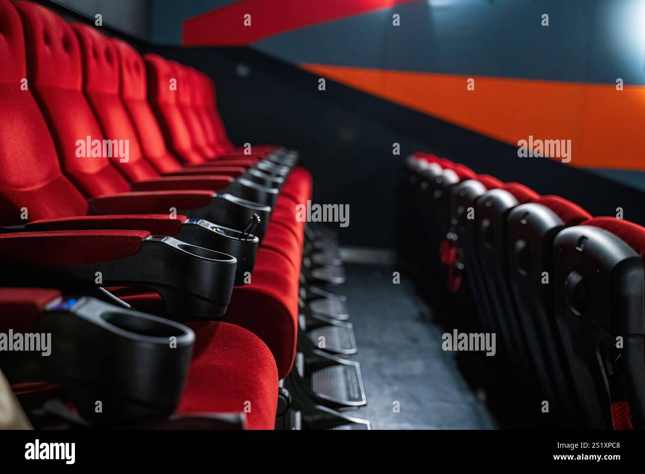 A closeup of inviting red seats in a modern movie theater. The image