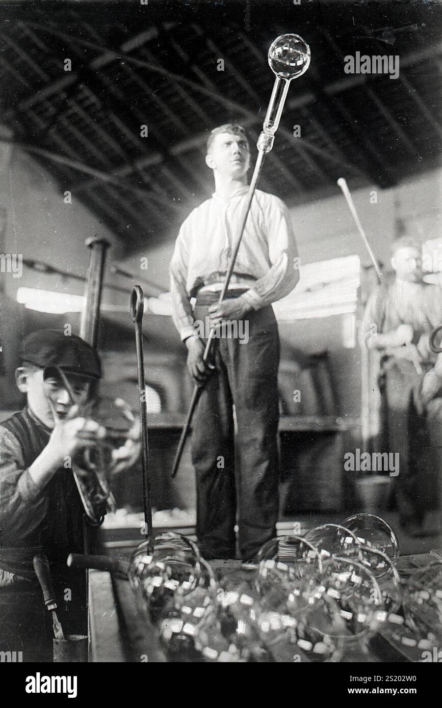 Workers in the Philips light bulb factories, glassblower at work. Netherlands, ca. 1910 Stock Photo