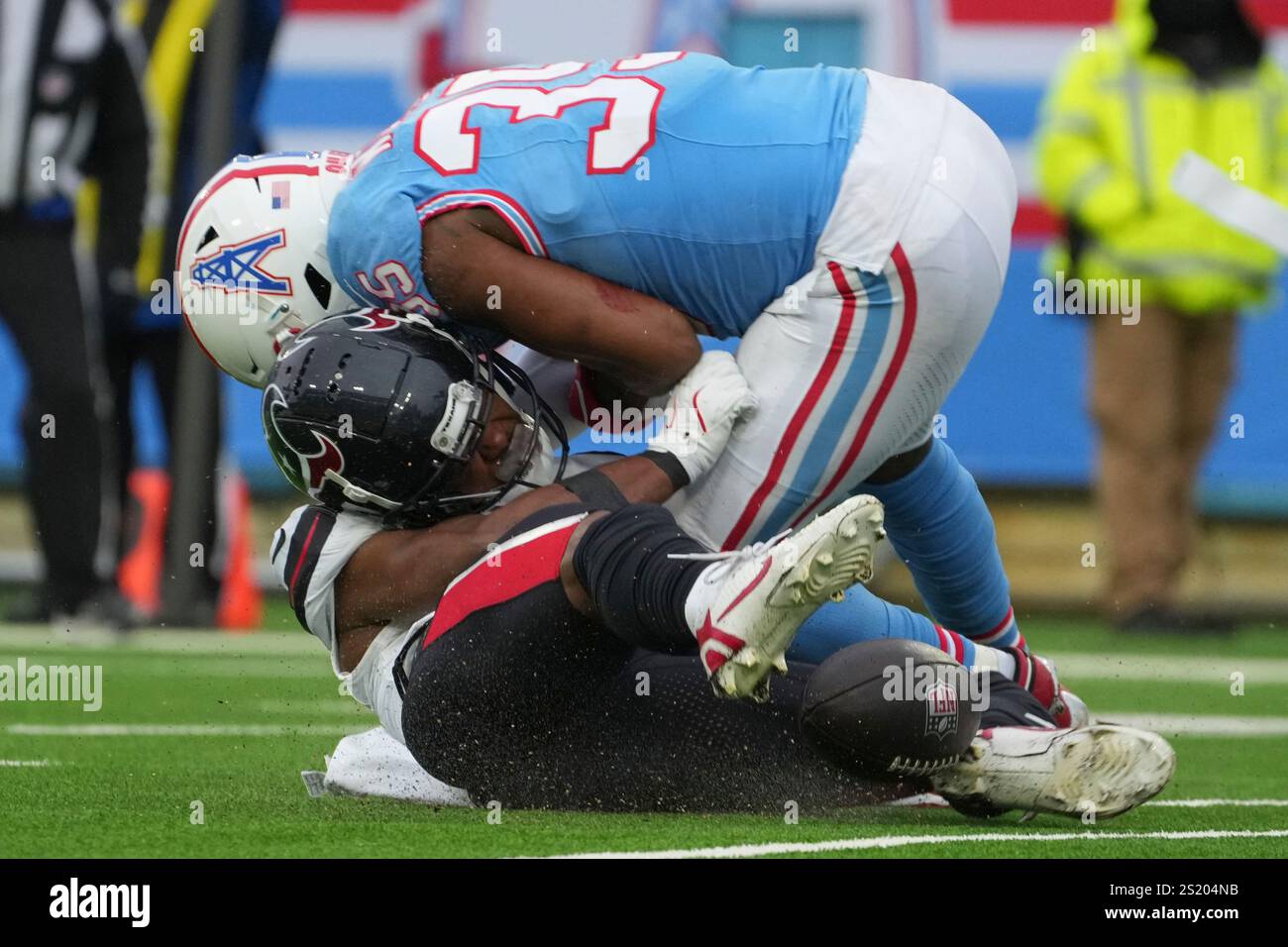 Houston Texans' John Metchie III, bottom, is hit by Tennessee Titans