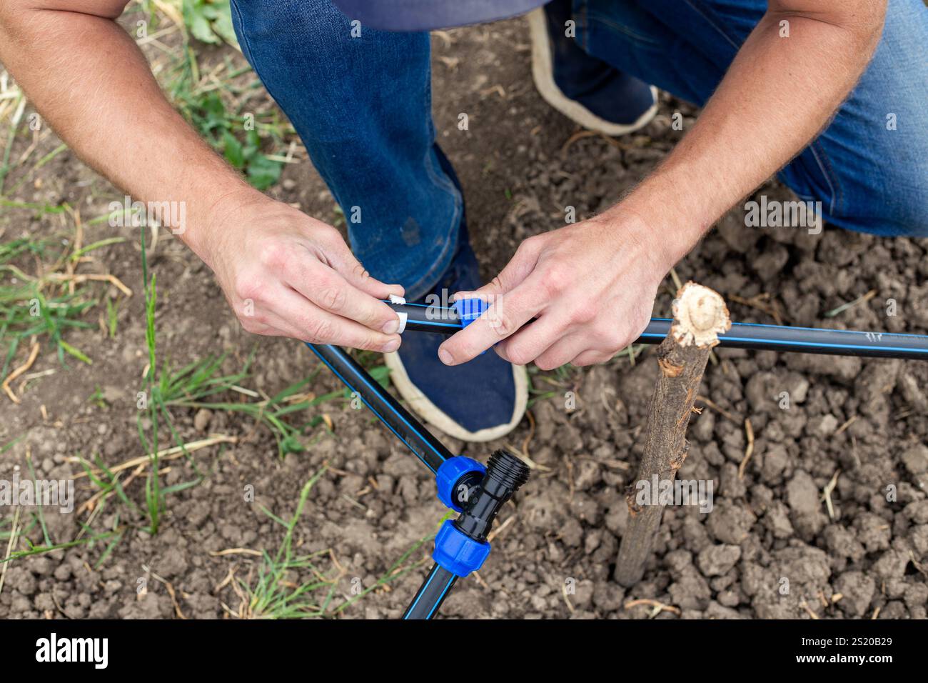 Fixing and connecting pipes using a fitting. man installs an automatic ...
