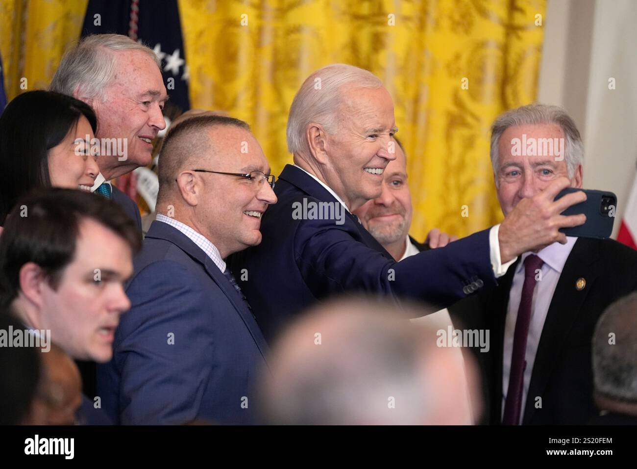 President Joe Biden takes a selfie with officials after signing the ...
