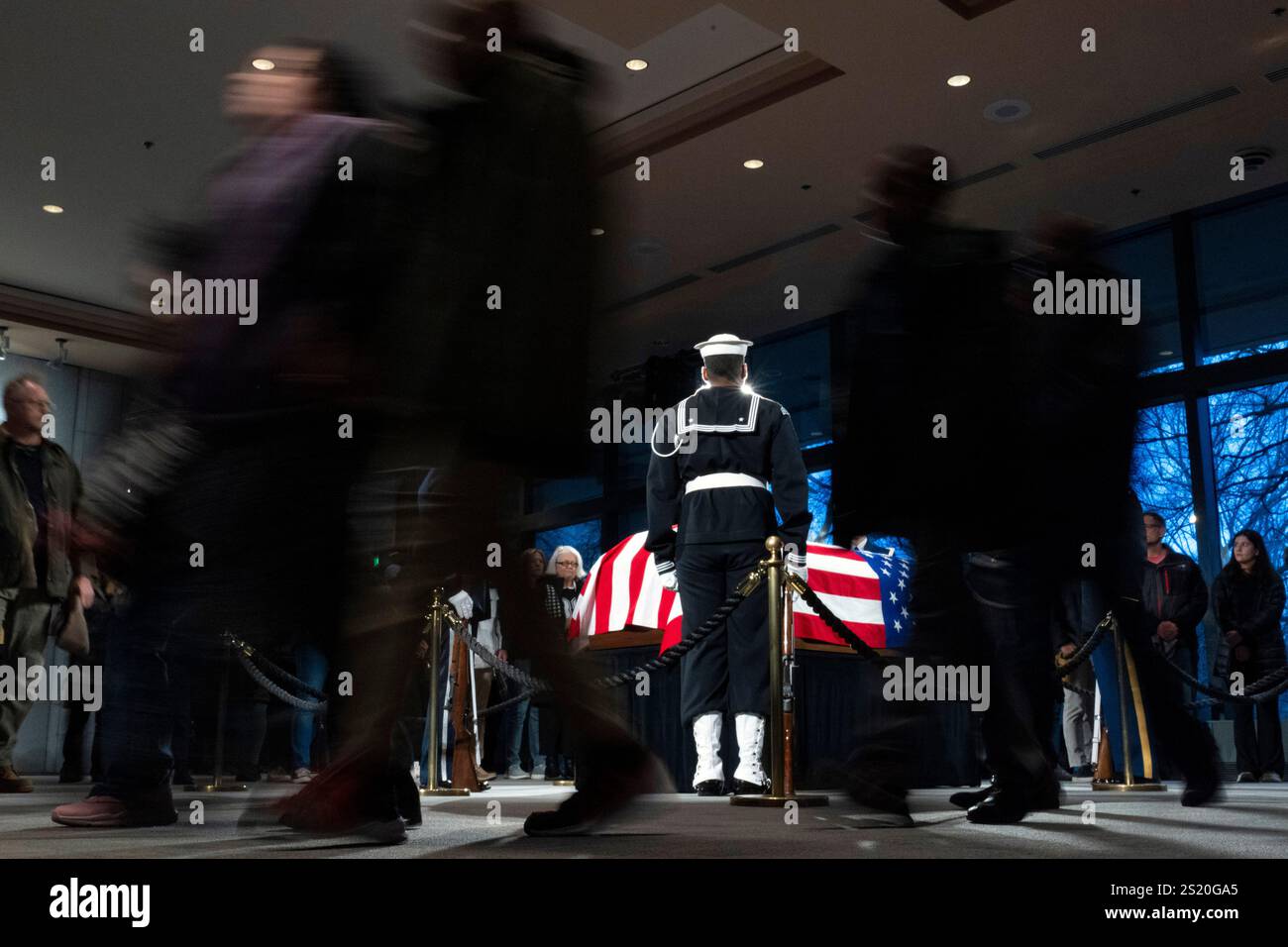 Mourners view the casket of former President Jimmy Carter as he lies in