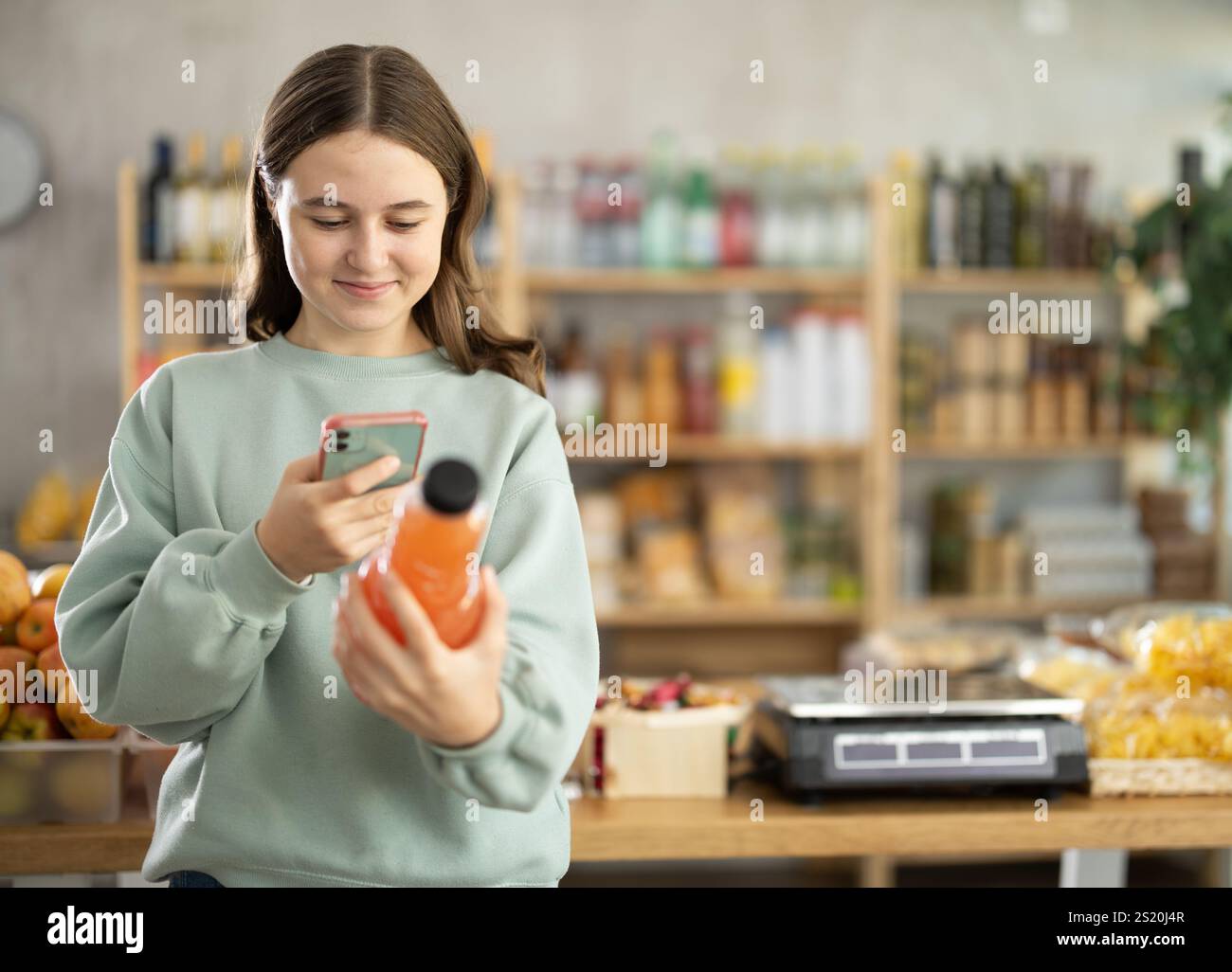 Teenage girl scanning qr code of grapefruit juice Stock Photo - Alamy