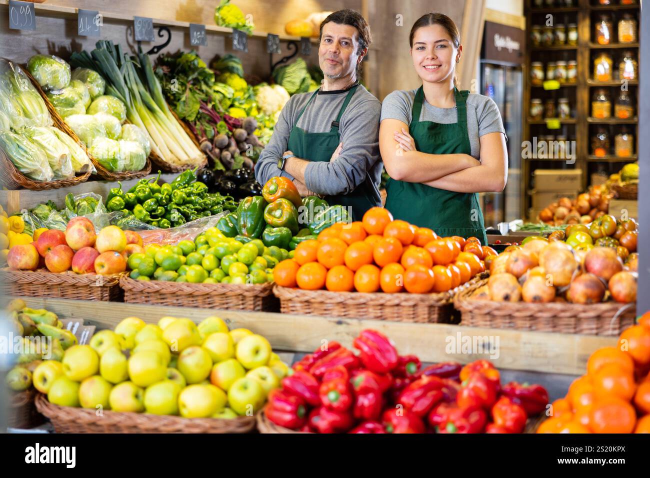 Male and woman sellers offering fruit and vegetables standing near ...