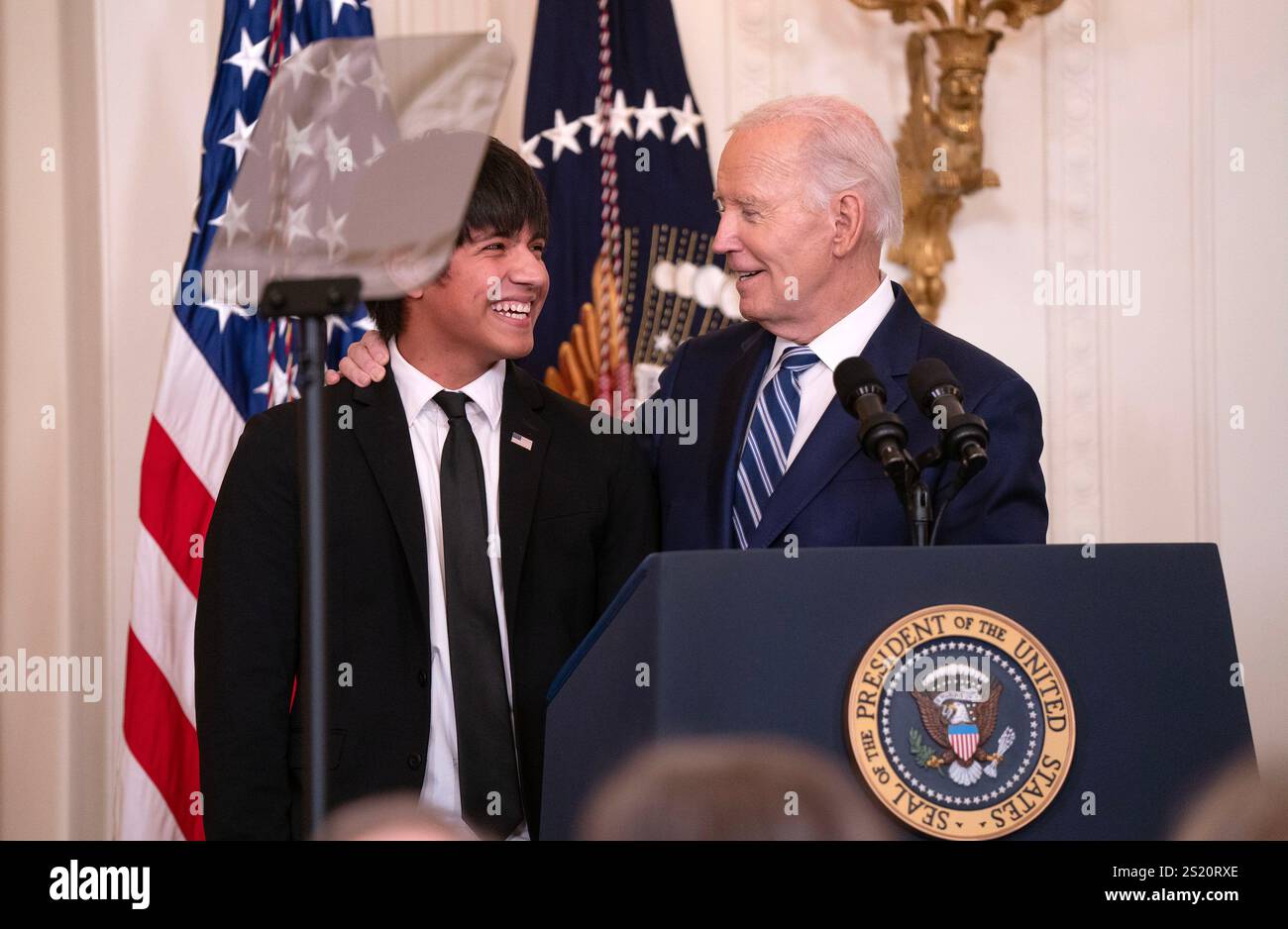 President Joe Biden puts his arm around Lubbock, Texas high school