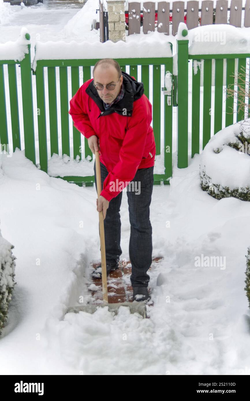 Snow is shovelled away from a house. Snow clearance in winter Stock Photo