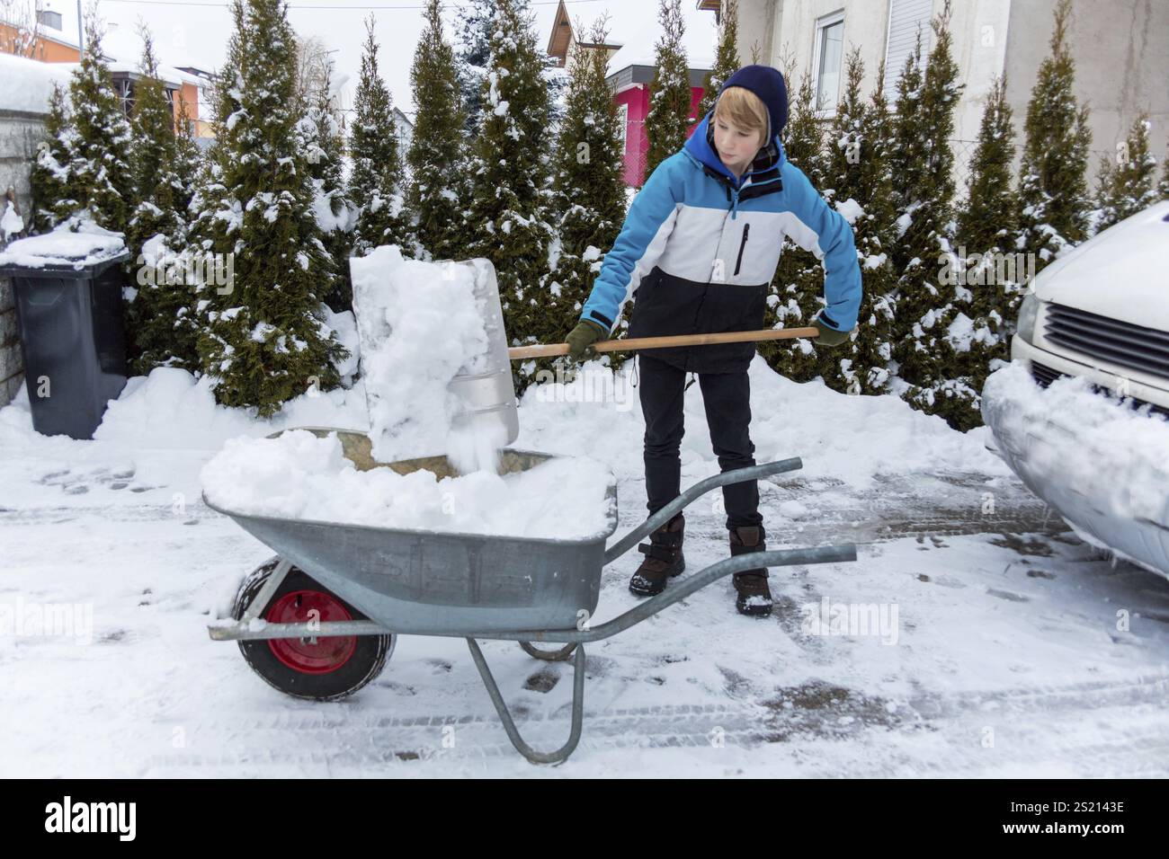 Snow is shovelled away from a house. Snow clearance in winter Stock Photo