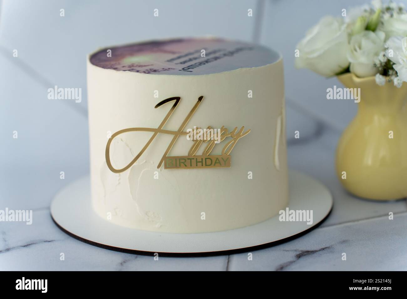 Minimalist white birthday cake with shiny gold Happy Birthday topper on ...