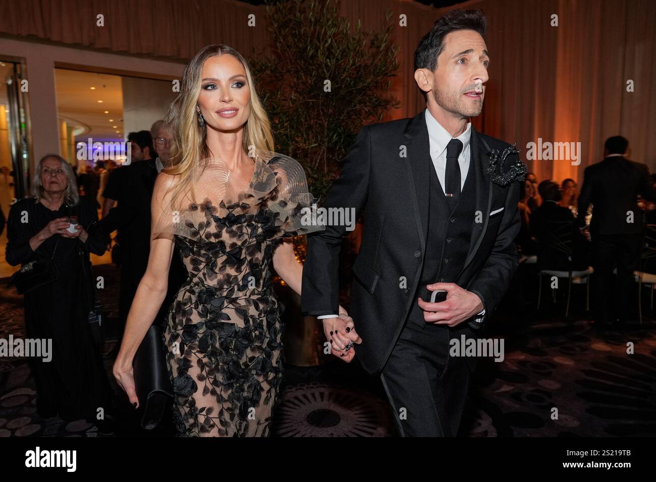 Chapman, left, and Adrien Brody arrive at the 82nd Golden