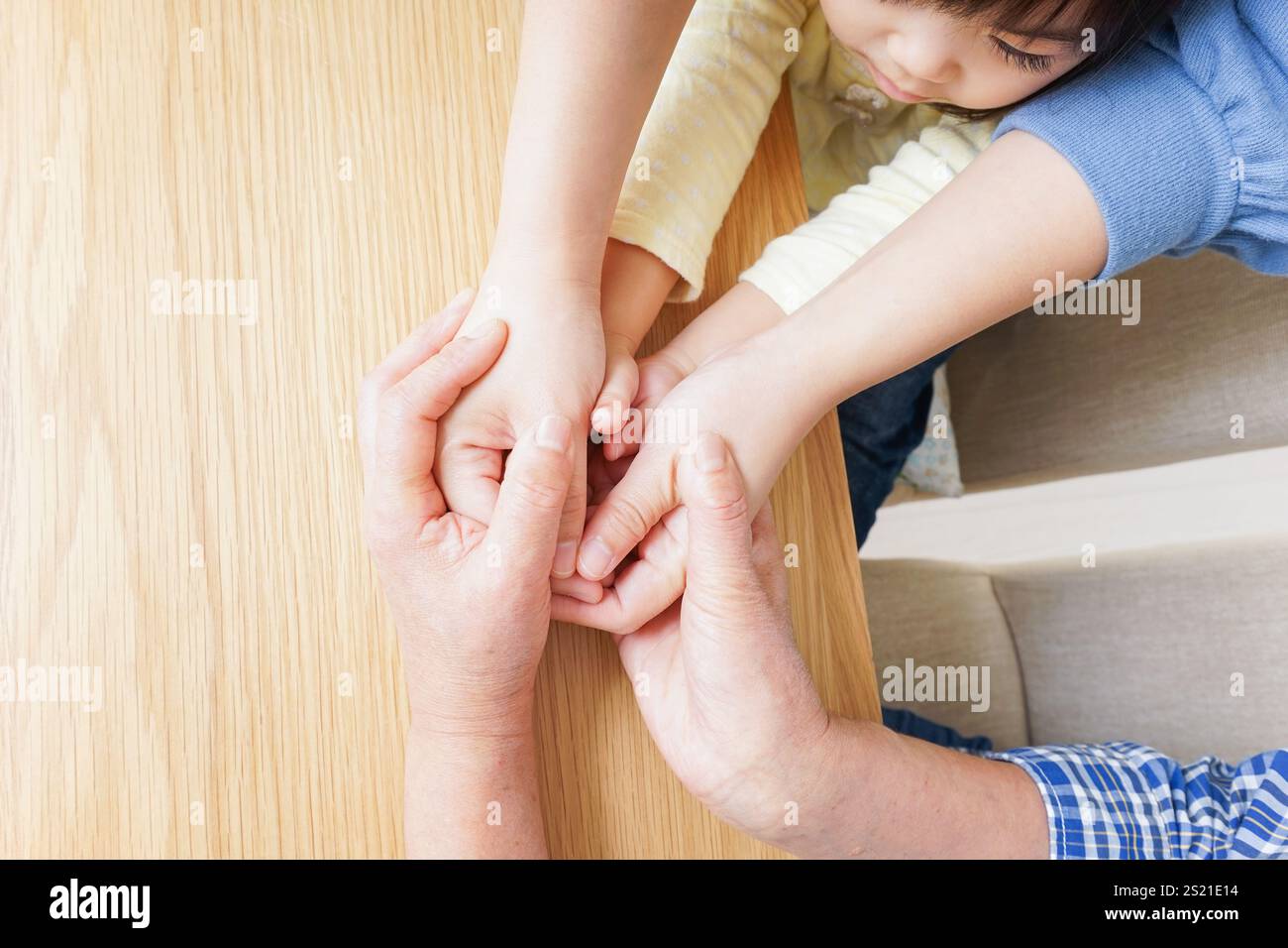 Mother and grandmother holding child's hand Stock Photo - Alamy