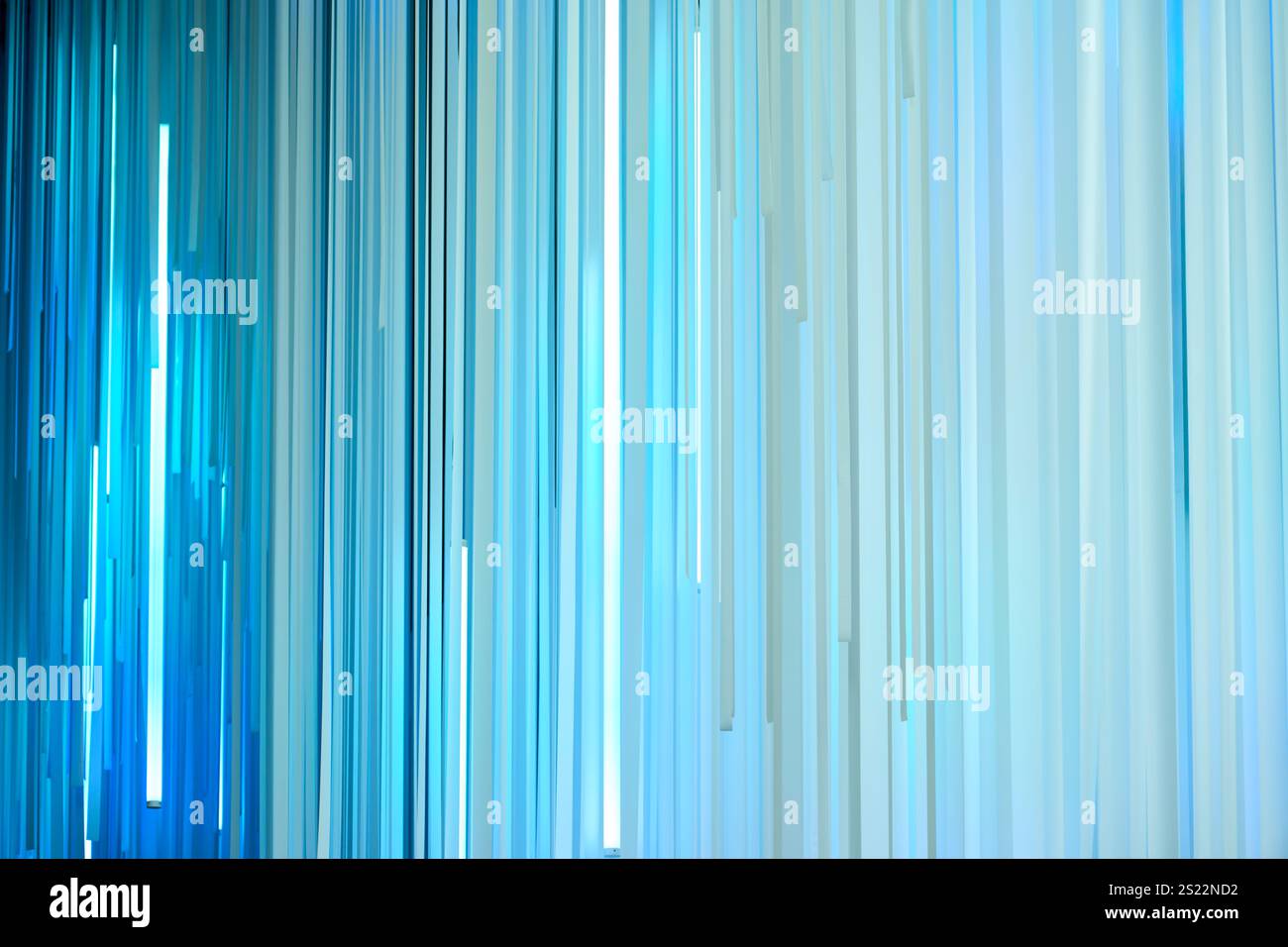 Light blue vertical stripes hanging and creating a modern abstract background Stock Photo