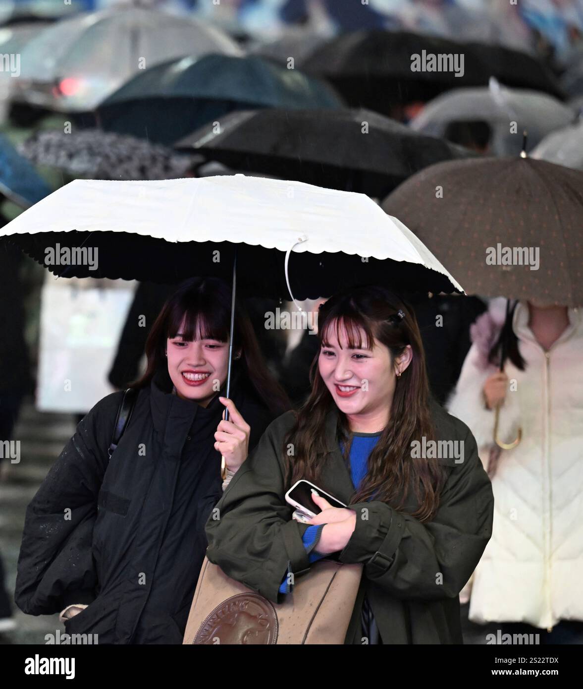 People cross the Shibuya scramble crossing in rain in Tokyo, on Jan. 6 ...