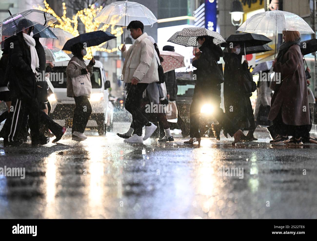People cross the Shibuya scramble crossing in rain in Tokyo, on Jan. 6