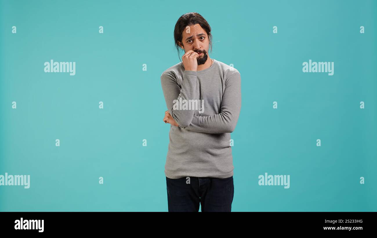 Distraught man biting nails, being afraid of receiving troubling bad ...