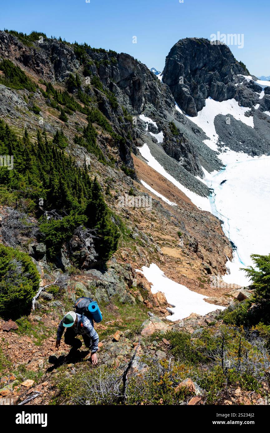 Backpacker Exploring Rugged Mountain Terrain with Snow-Capped Peaks ...