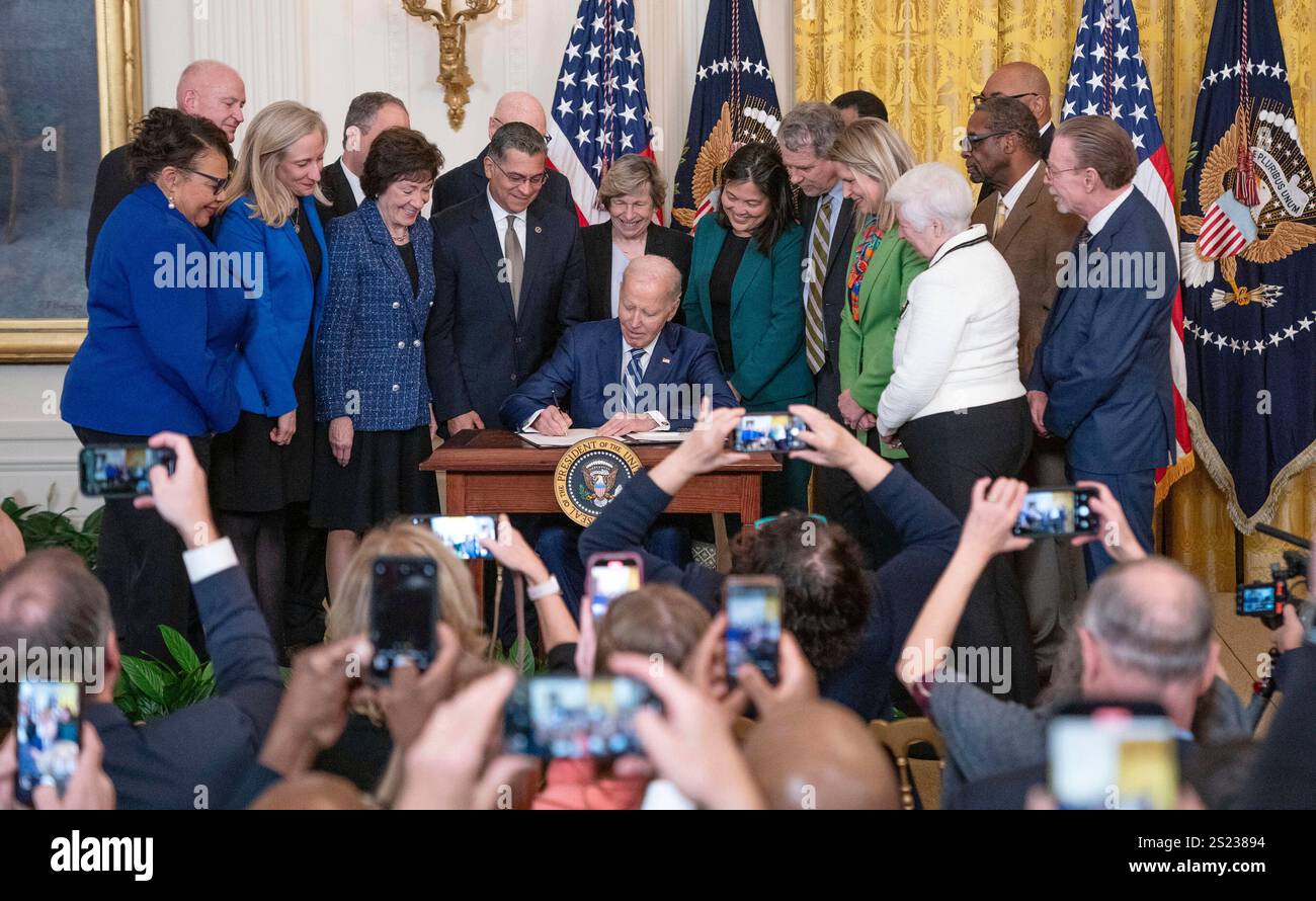 United States President Joe Biden signs the Social Security Fairness Act in the East Room of the
