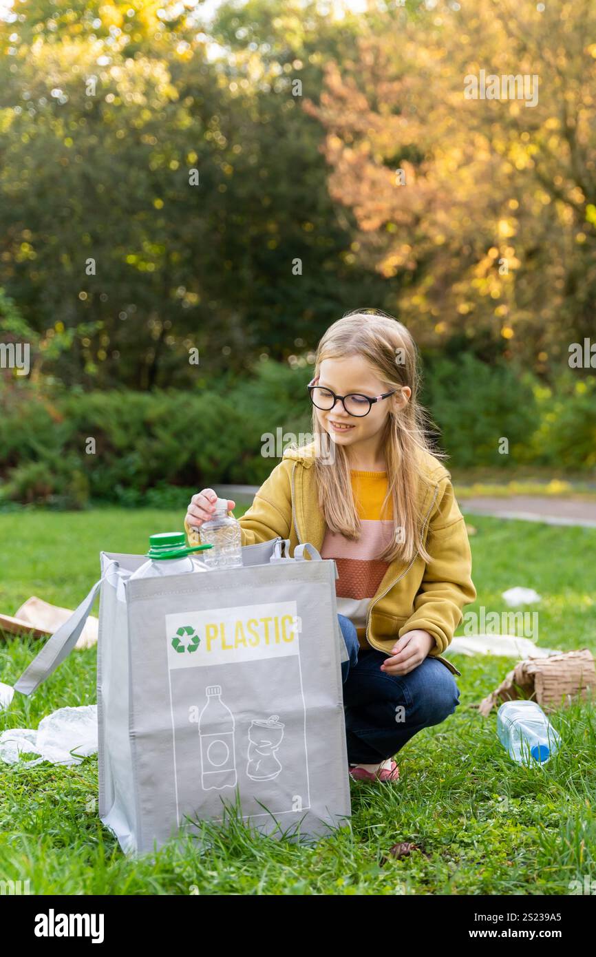 Sorting Garbage Child Caucasian female child sorting waste into bags in park promoting ...