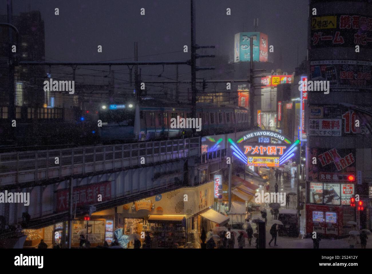 A snowy night in Ameyoko Market near Ueno Station, Tokyo. The bustling street, illuminated by neon lights, is quieted by heavy snow. Stock Photo