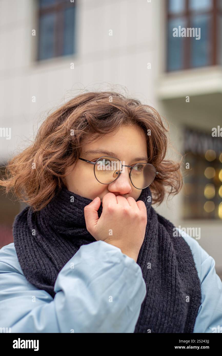 Freezing woman. A young beautiful frozen girl suffers from cold weather ...