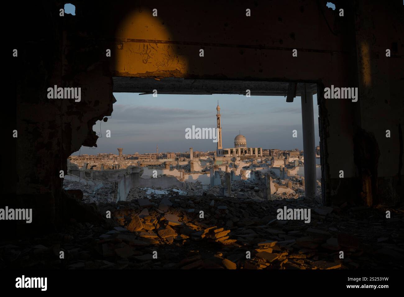 A heavily damaged mosque stands next to buildings that were completely ...