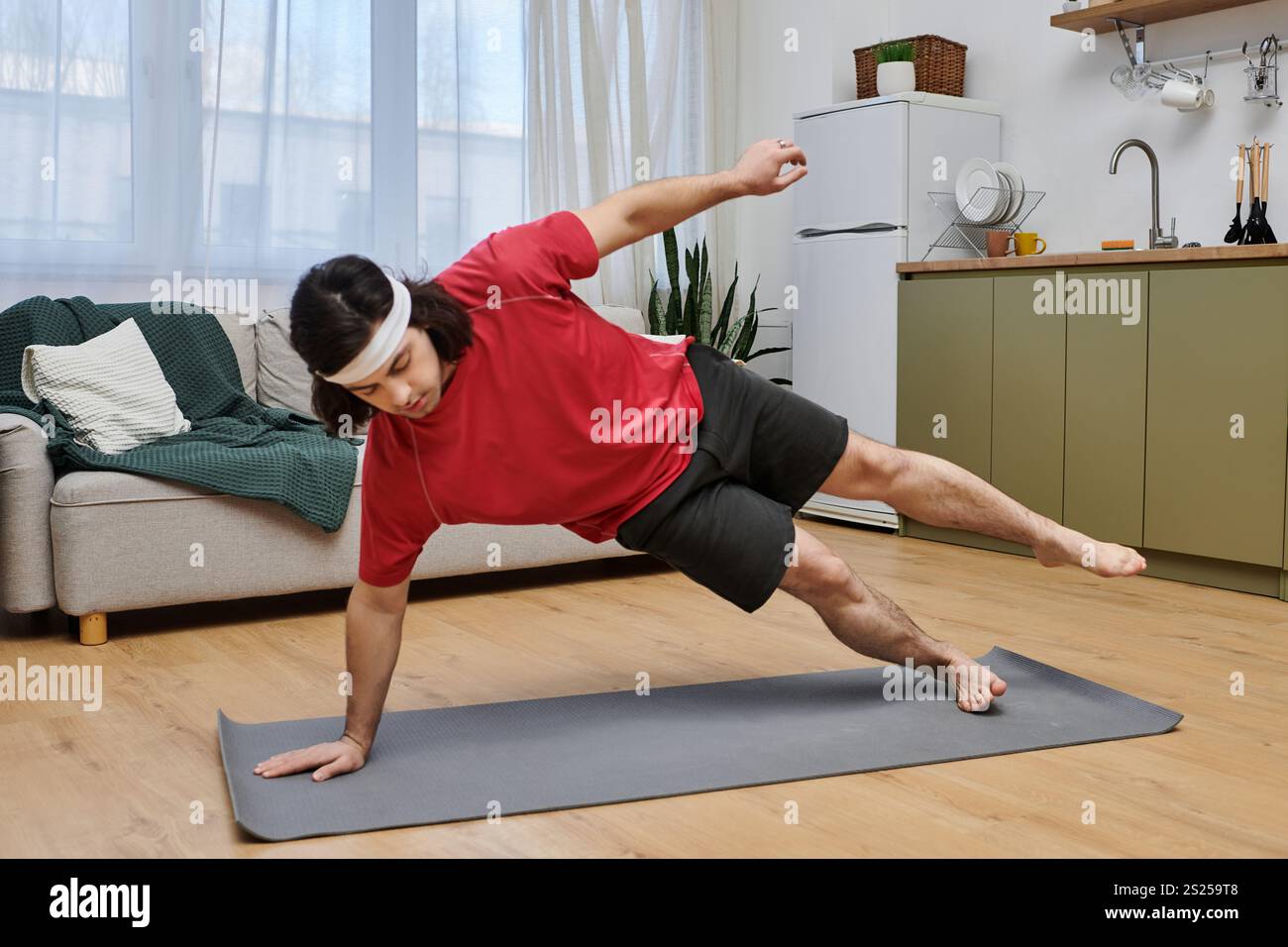 Energetic young adult enjoys his daily fitness routine on a mat in a ...