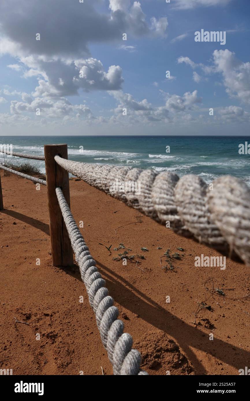 Rope fence on the beach with blue sky and sea in background in Netanya ...