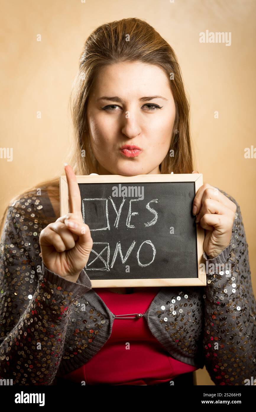 Portrait of young woman showing checked box with answer