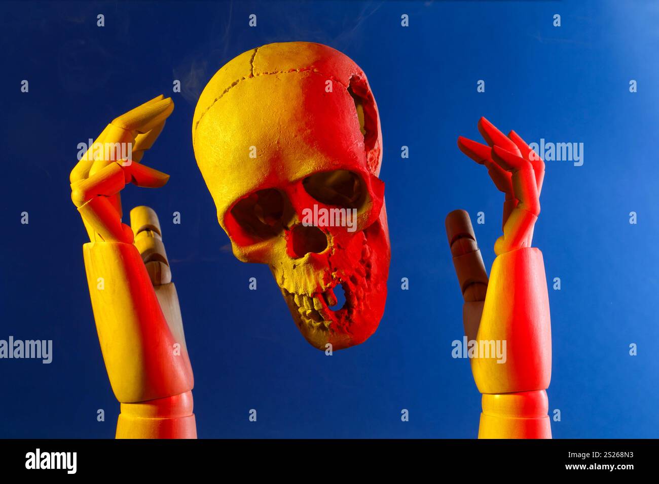 Human skull and mannequin hands on blue background Stock Photo