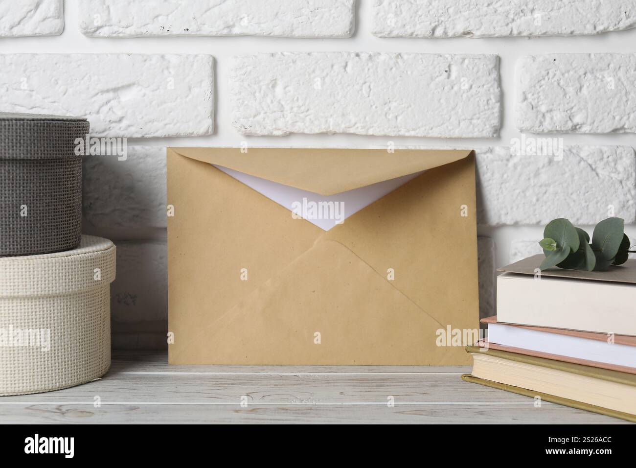 Kraft paper envelope with letter, boxes and books on wooden table near ...
