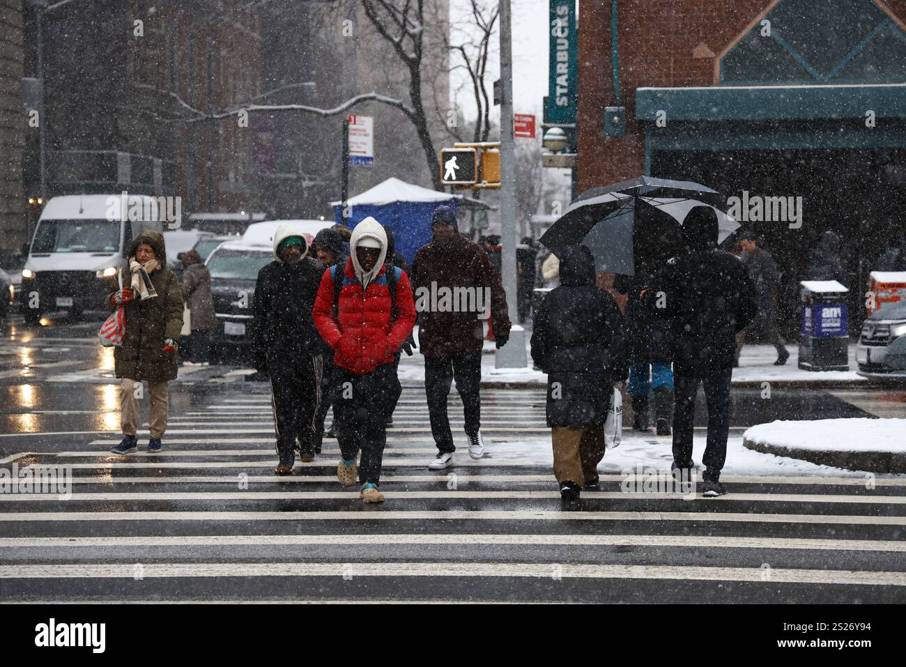 People cross the street at Union Square Park as snow falls in New York ...