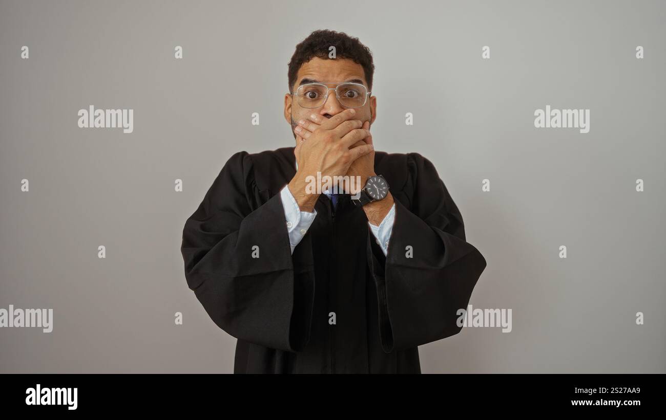 Young man in judge robe looking surprised with hands over mouth on ...