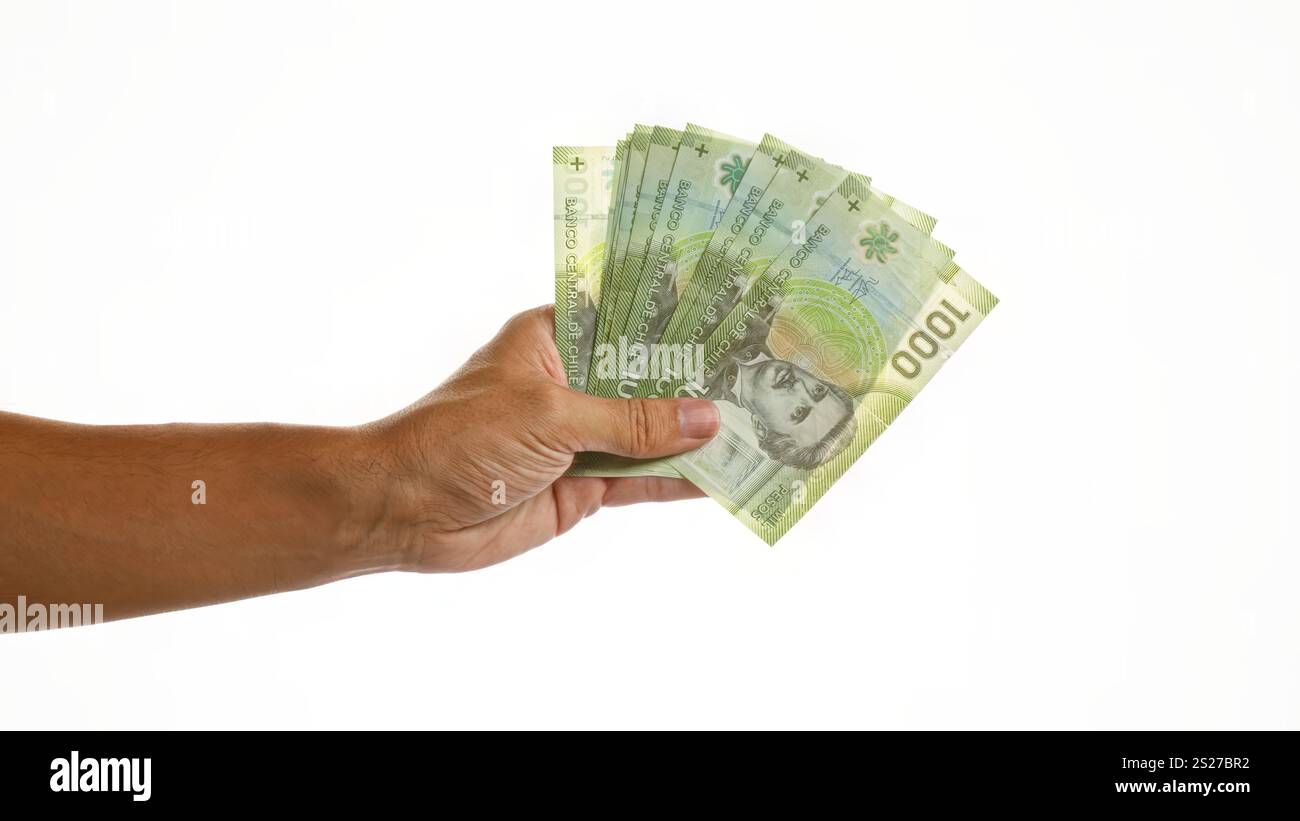 Hand holding several chilean pesos over an isolated white background