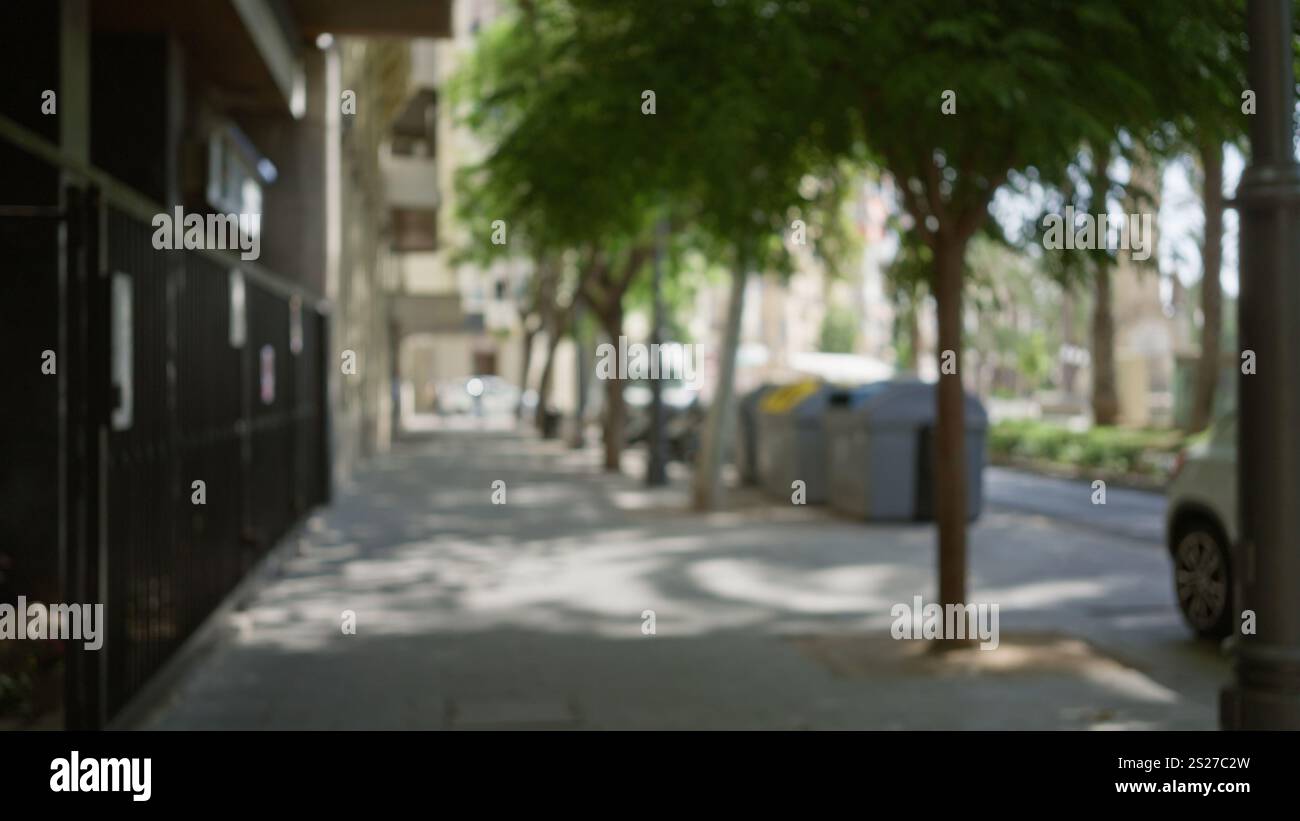Blurred outdoor scene on a city street with green trees, buildings, and ...