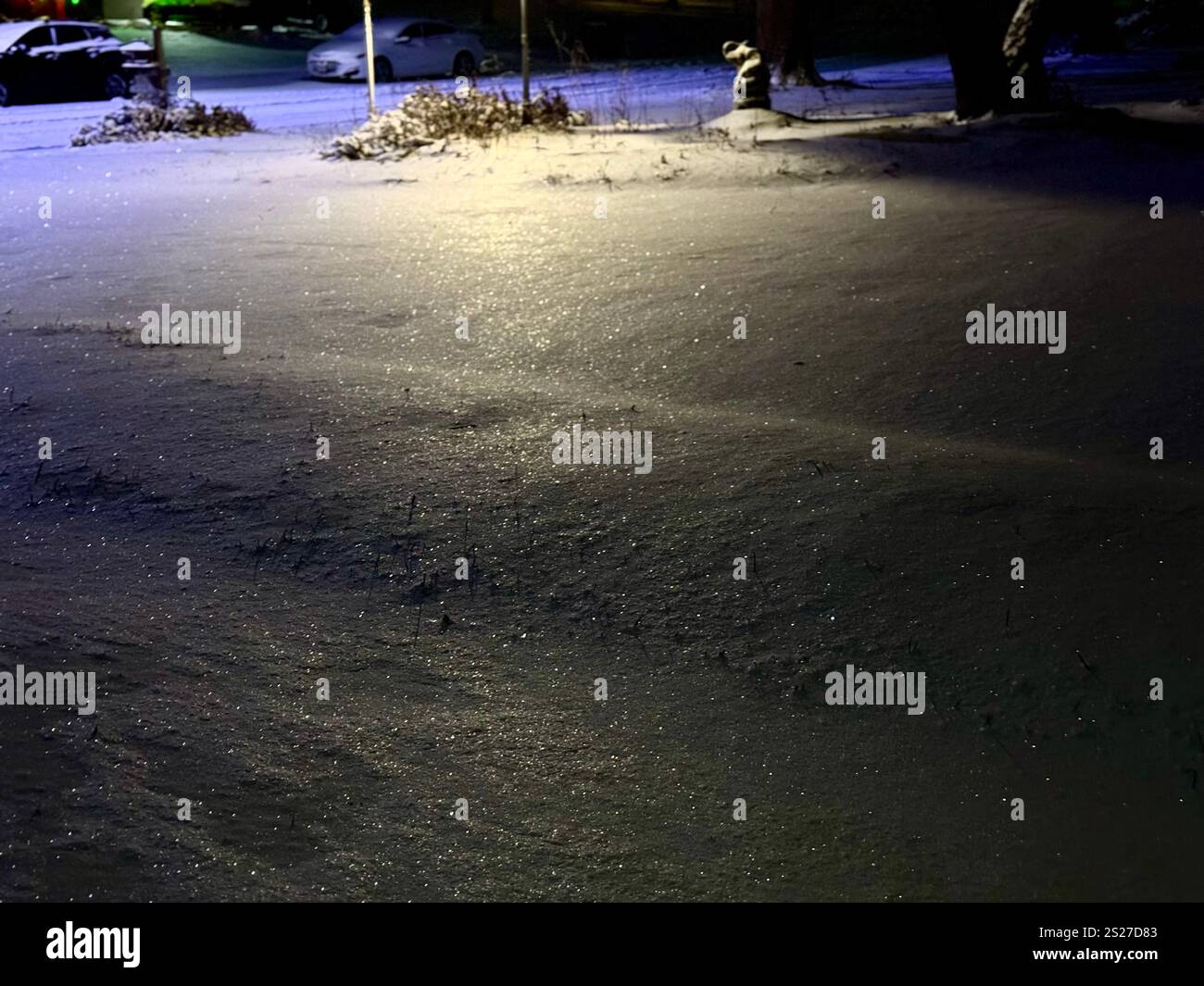 Snow sparkles under artificial lights after dark in Wichita, Kansas, USA. - Smartphone Captured Stock Image