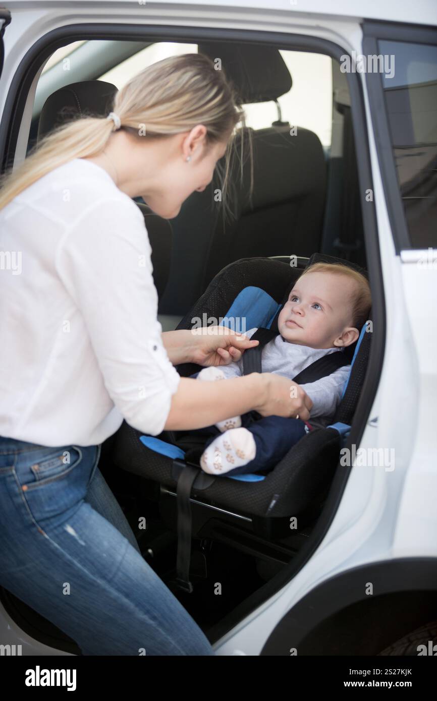 Mother seating her baby in car safety seat Stock Photo - Alamy