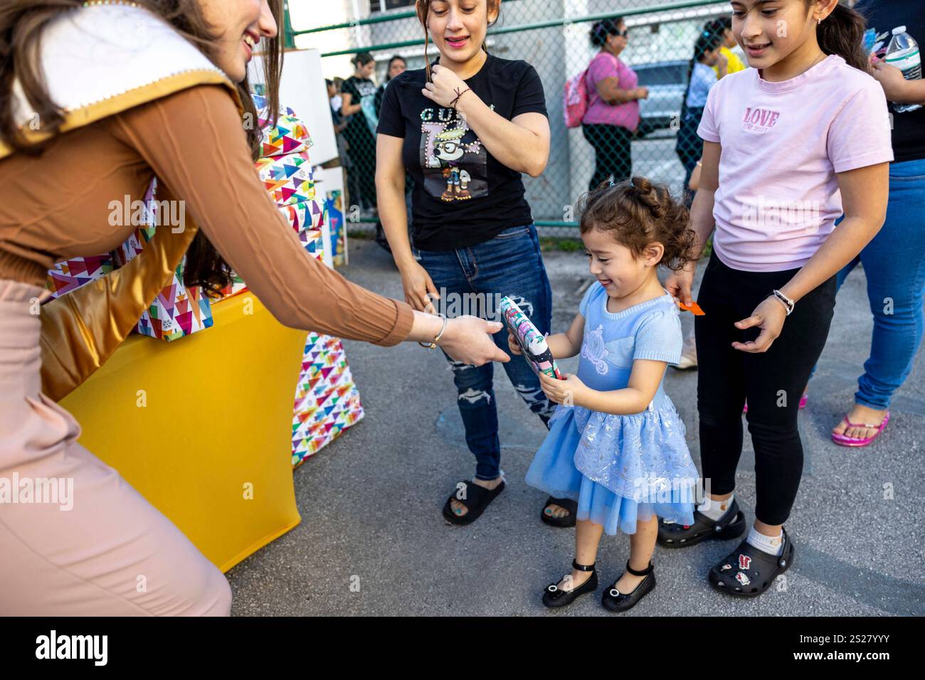 Miss Carnaval Miami 2024, Delaney Milian, 23, hands a gift to Natalia