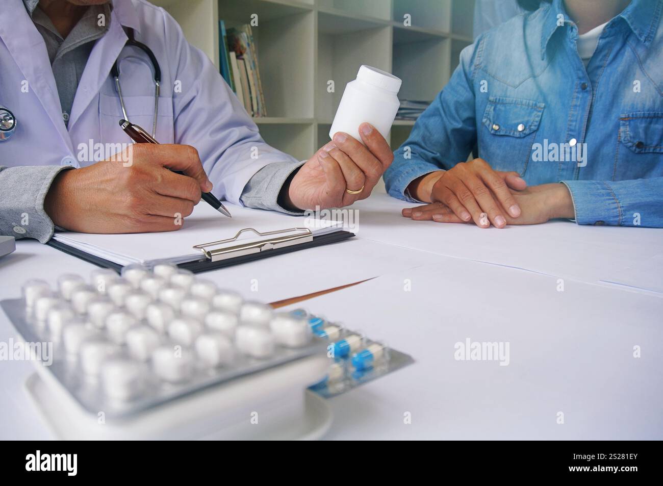 Doctor hand holding pack of different tablet blisters for patient. prescribe medicament. disease healing concept. Stock Photo